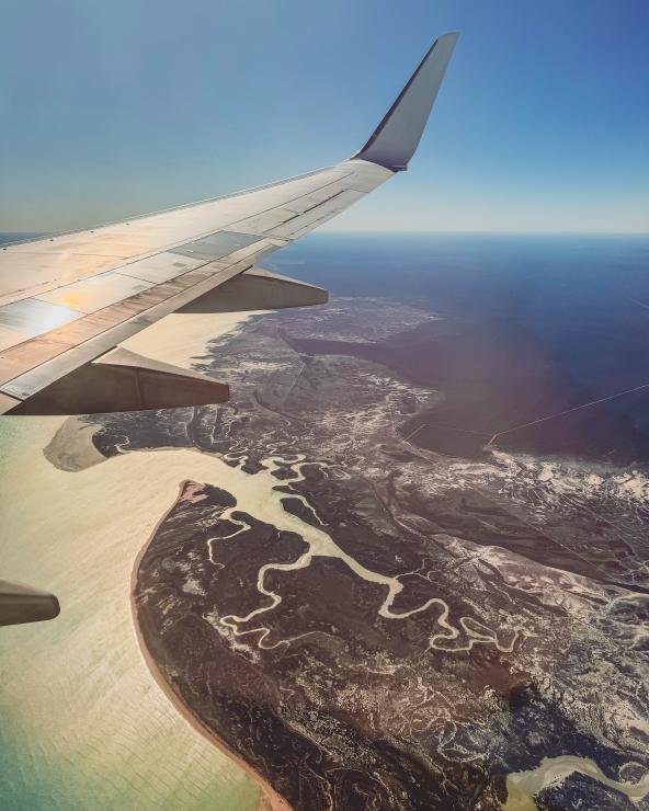 Flugzeugflügel über der Küstenlinie von Nordwestaustralien mit Flussmündungen