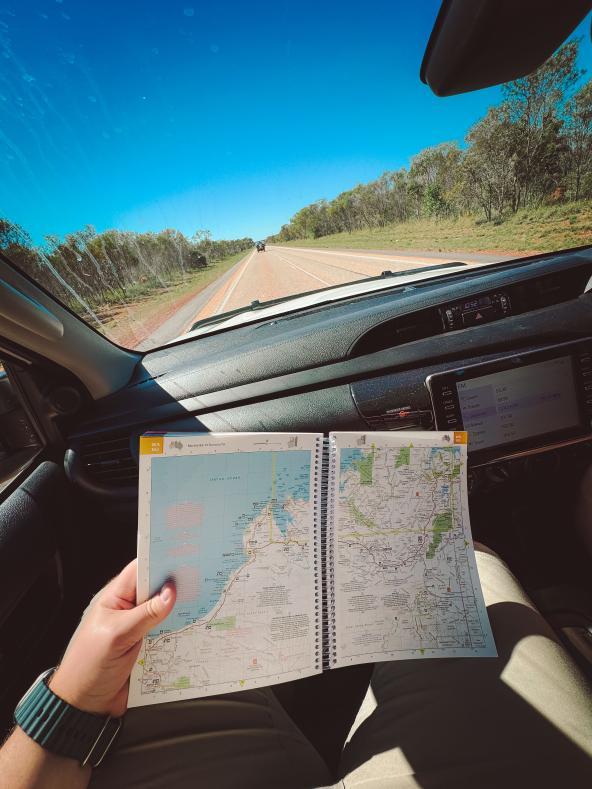 Straßenkarte auf dem Schoß eines Mitfahrers im Geländewagen auf australischer Landstraße