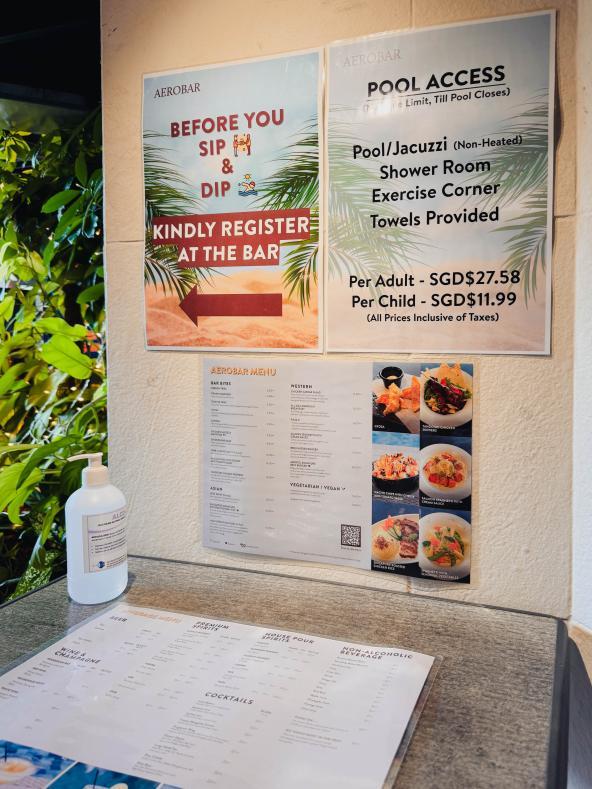 Hinweisschilder und Menü am Aerobar-Pool im Flughafen Singapur.