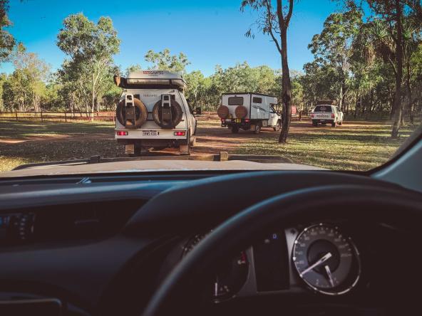 Geländefahrzeuge parken auf einem roten Sandweg bei Mt Elizabeth Station