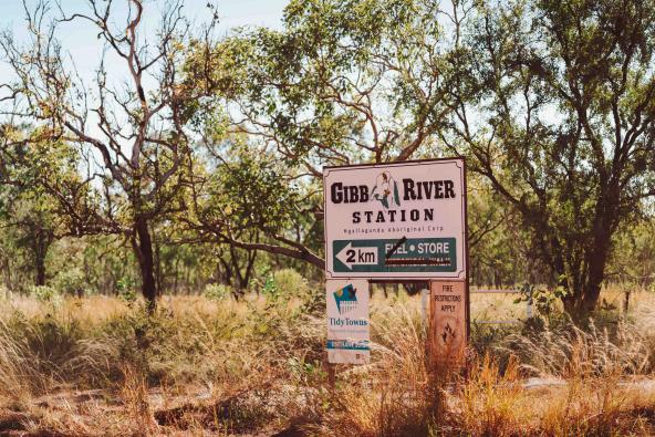 Schild der Gibb River Station mit durchgestrichenem Hinweis auf Treibstoff, umgeben von australischer Buschlandschaft