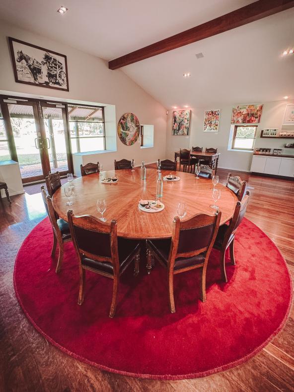 Runder Holztisch mit Weingläsern im Verkostungsraum eines Weinguts bei Perth