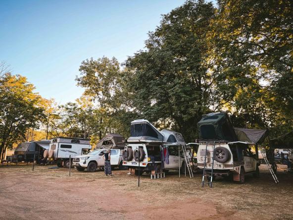 Geländewagen mit Dachzelten und Campern auf einem schattigen Campingplatz in El Questro