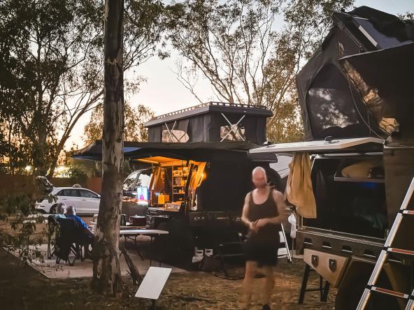 Offroad-Camper mit aufgeklappten Dachzelten, Outdoor-Küche und Technik im Abendlicht.